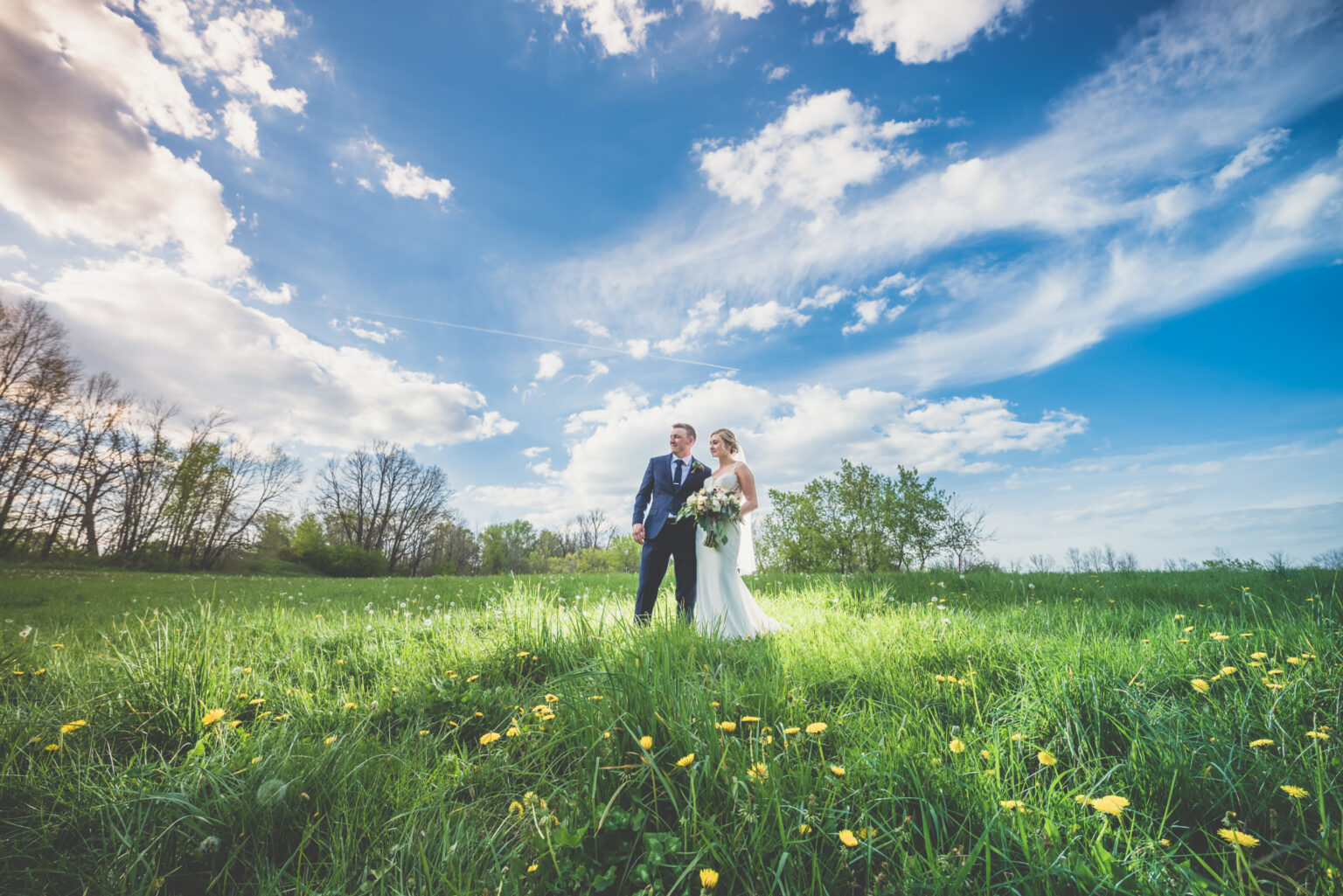 A couple in a field in Wisconsin on their wedding day.