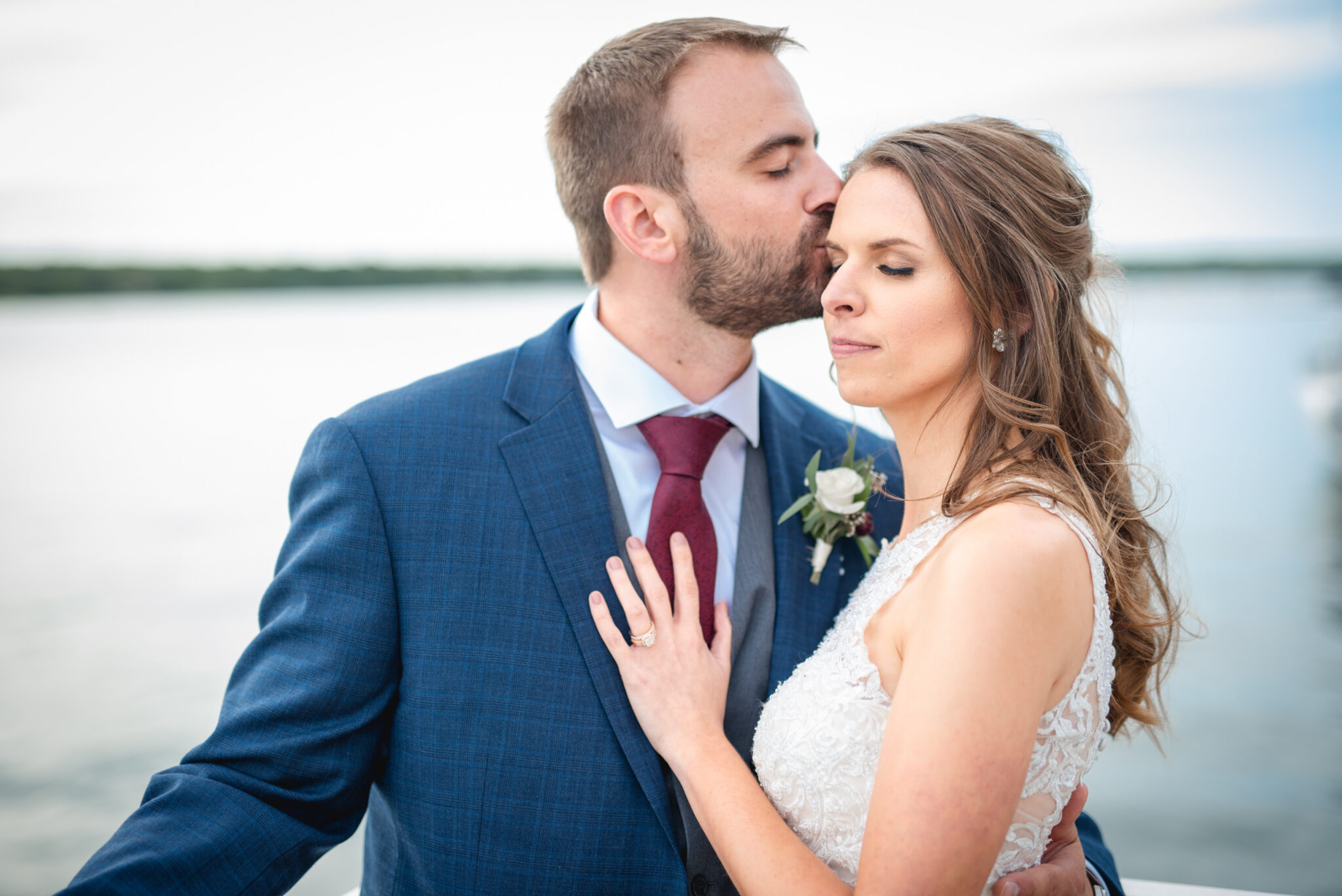 Husband kissing his new wife on the shores of door county wisconsin