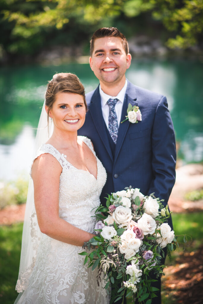 A couple on Elkhart lake in wisconsin on their wedding day for portraits with the lake in the background