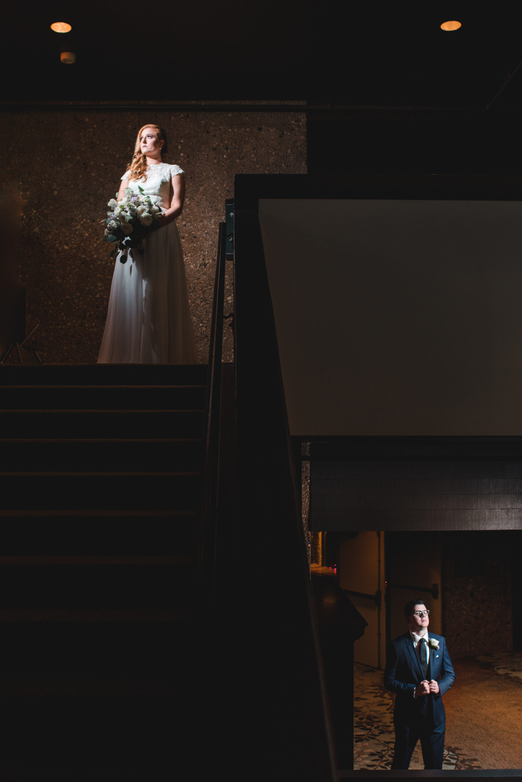 artistic photo of woman and man on stairs after their wedding each on separate levels in lake geneva wisconsin
